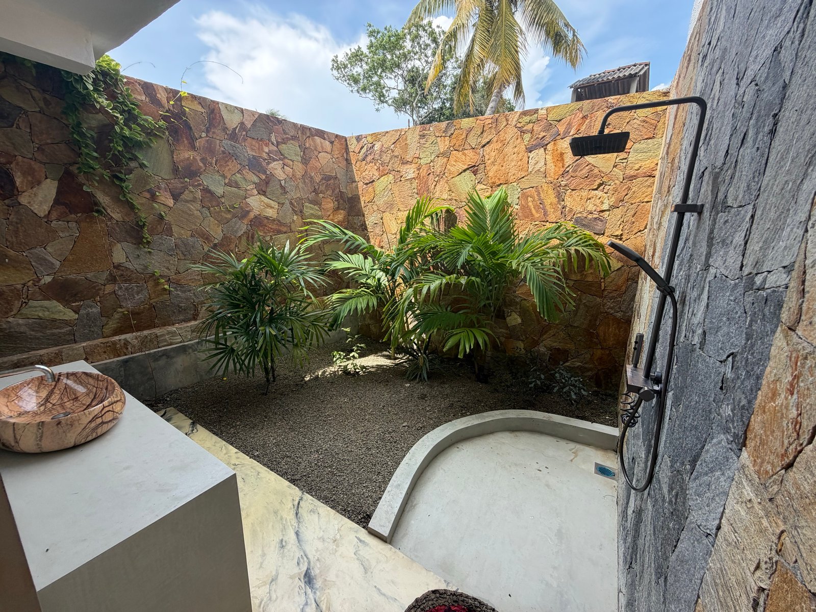Large downstairs bedroom — a wider view of its plant-filled outdoor shower room.