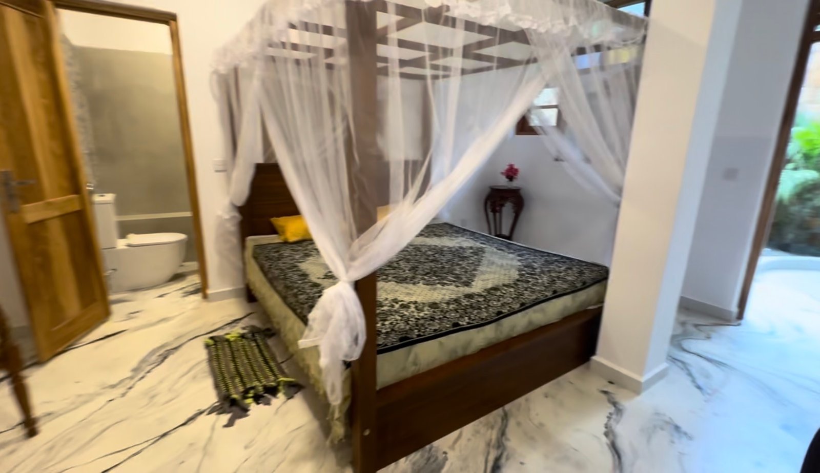 Main downstairs bedroom — super-king bed, ceiling fan and no air conditioning. Large private outdoor shower room with basin, plus a separate indoor toilet room with basin.